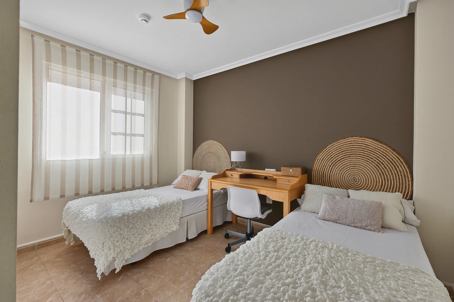 Twin bedroom with a grey-green color cast before and true whites and warm wood tones after AI color correction by Stager AI