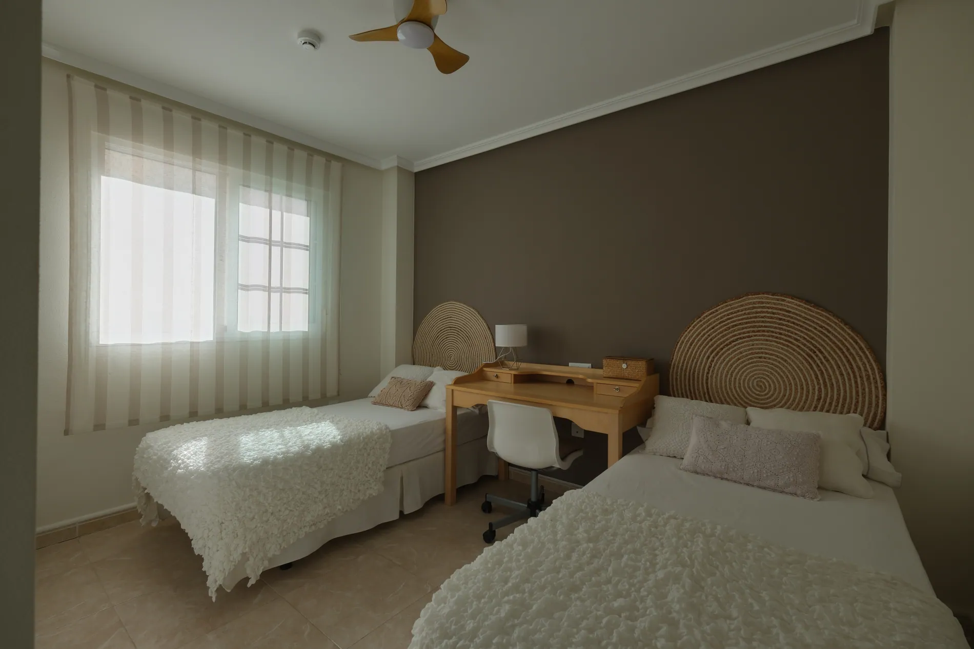 Twin bedroom with a grey-green color cast before and true whites and warm wood tones after AI color correction by Stager AI