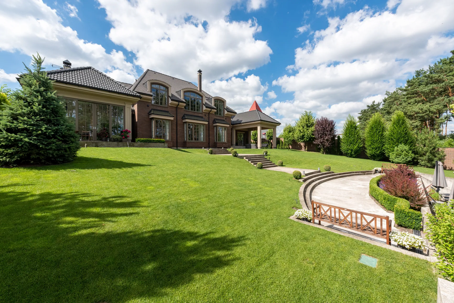 Brick manor house with a large lawn turned from a daytime photo into a twilight shot with glowing windows by Stager AI