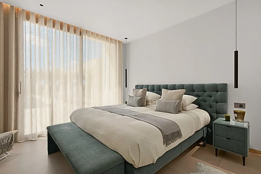 Modern bedroom with floor-to-ceiling sheer curtains and a tufted green headboard, edited with Stager AI
