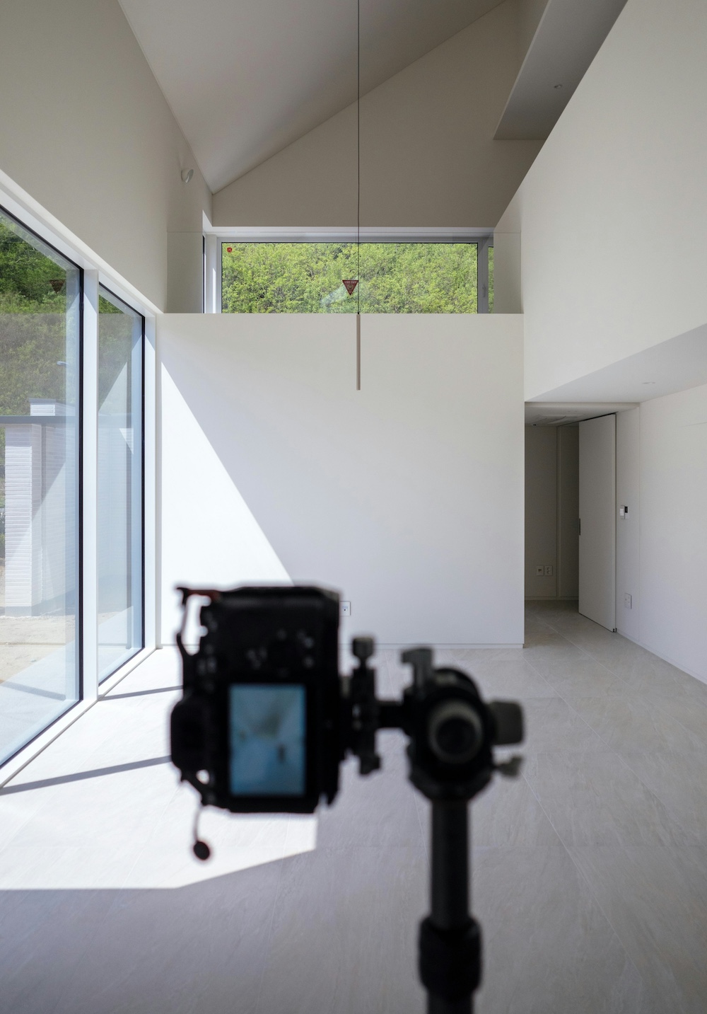 Camera on a tripod set up to shoot bracketed exposures inside a room